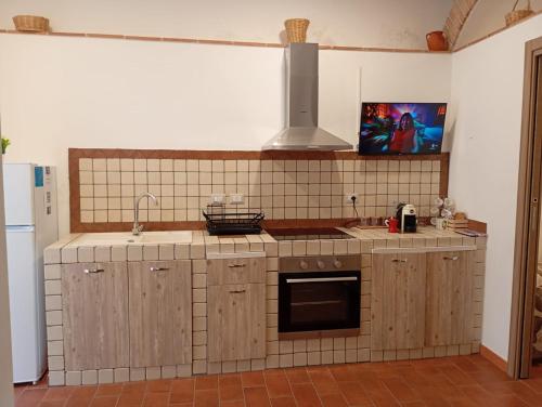 una cocina con fregadero y estufa horno superior en Rifugio nel borgo, en Monasterace