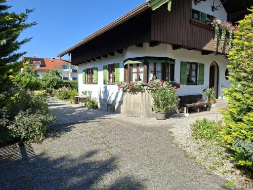 a white house with a bench in front of it at Haus Mayer in Weilheim in Oberbayern
