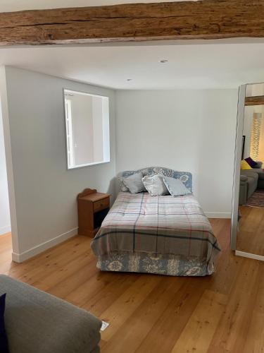 une chambre avec un lit et un miroir dans l'établissement La Biche, à La Celle-sous-Gouzon