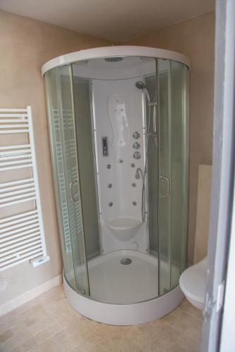 une douche avec une porte vitrée dans une salle de bain dans l'établissement Le Mas d'Elise, à Saint-Hippolyte-de-Caton