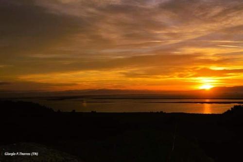 a sunset over a body of water with the sun setting at Villa Sa Marchesa in Solanas