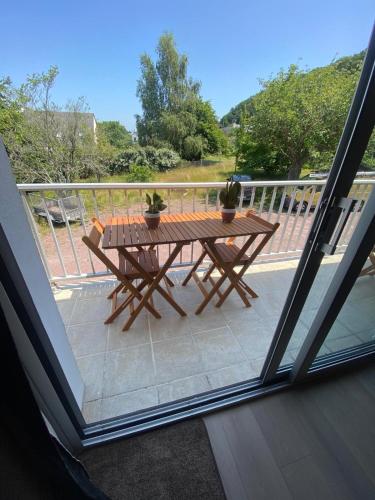 - une table de pique-nique en bois sur un balcon avec vue dans l'établissement Le Loft Corail, à Jullouville