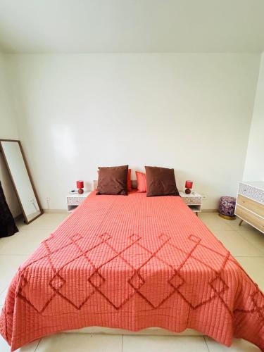 una camera da letto con un letto con un piumone rosso di Un Écrin de Sérénité à Dakar Point E a Dakar