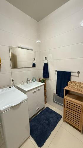 un bagno bianco con lavandino e specchio di Un Écrin de Sérénité à Dakar Point E a Dakar