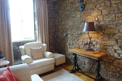 a living room with a chair and a table with a lamp at The Annexe, in 18th century Lothersdale Mill in Lothersdale
