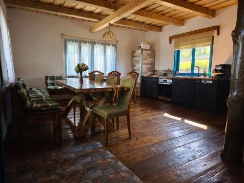 a kitchen with a wooden table and chairs in a room at Căsuța de la munte in Bistriţa