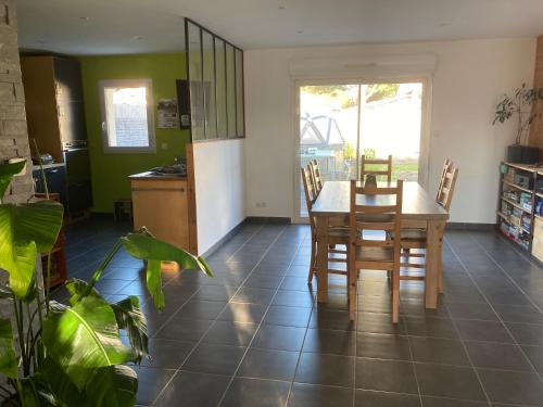 une cuisine et une salle à manger avec une table et des chaises dans l'établissement La maison de Nico et Amandine, à Commequiers
