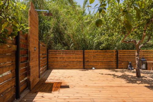 a wooden fence with a wooden walkway next to a tree at Lemonanthos Villa in Káto Kalésia