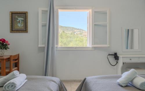 a bedroom with a bed and a window at Fexulis Studios & Suites in Agios Nikolaos