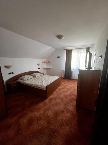 a bedroom with a bed and a large window at Casa Veverita in Predeluţ