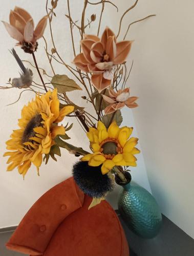 a vase with flowers in it on a table at Freude Unterkunft Basel in Allschwil