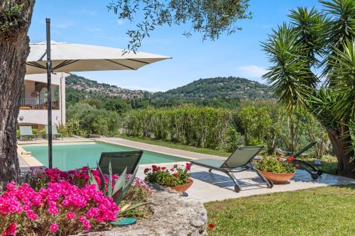 une piscine avec deux chaises et un parasol et des fleurs dans l'établissement Domaine Ousta Baio, à Grasse