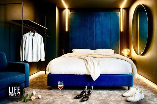 a bedroom with a bed with a blue wall at LIFE VOYAGE & SPA - Strasbourg's City Center Luxury Experience in Strasbourg