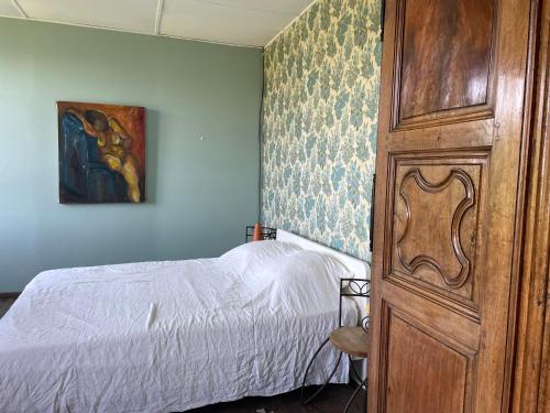 une chambre avec un lit et une armoire en bois dans l'établissement Maison de famille Victorine, à Lamastre