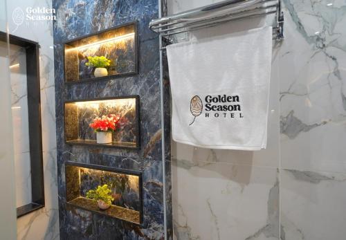 a sign for a garden season hotel on a wall with potted plants at Golden Season Hotel in Cairo