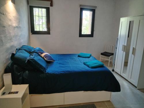 une chambre avec un grand lit avec des draps bleus dans l'établissement Gites Torreillans - Nid douillet, à Torreilles