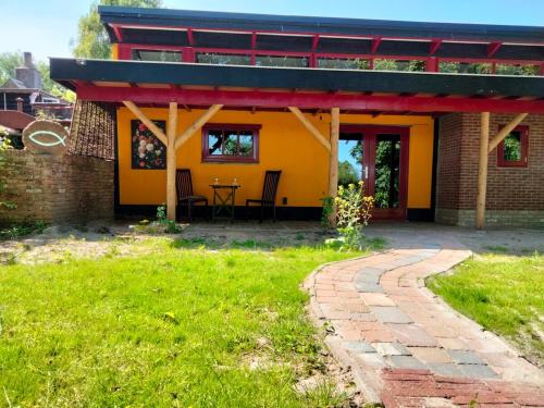 a house with a red roof and a brick path at Mus in Vierhuizen