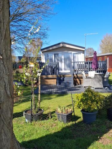 a backyard with a gazebo with chairs and a tree at Holiday Home on Billing Aquadrome in Great Billing