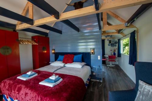 a bedroom with a large bed with red and blue sheets at Huize Breelzicht in Mirns