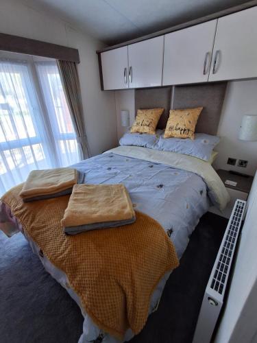 a bedroom with a large bed with towels on it at Holiday Home on Billing Aquadrome in Great Billing