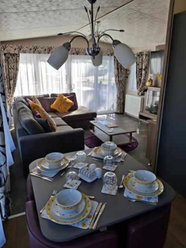 a living room with a table with dishes on it at Holiday Home on Billing Aquadrome in Great Billing