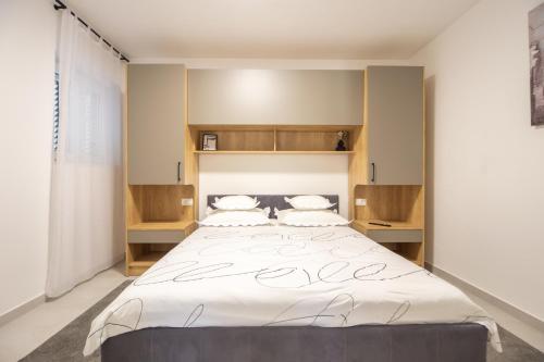 a bedroom with a large bed with two pillows at Villa Alesa Steva in Tučepi