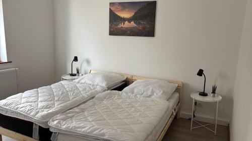 two twin beds in a room with two tables at Tannenhaus 3 bedrooms in Kassel