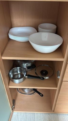 a cupboard with plates and bowls and a bowl andplates at Tannenhaus 3 bedrooms in Kassel