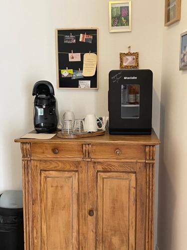une armoire en bois avec un micro-ondes et une cafetière dessus dans l'établissement Maison Côté Halle 