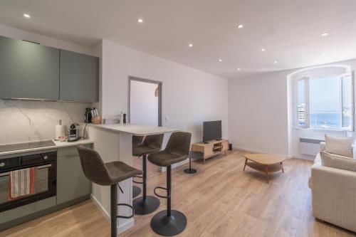 une cuisine et un salon avec une table et des chaises dans l'établissement T2 40m2 climatisé centre ville FESCH, à Ajaccio
