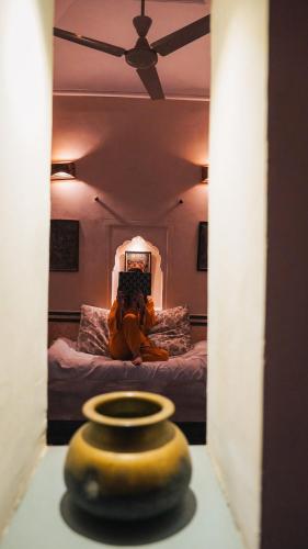 a teddy bear sitting on a bed in a room at Mandawa Kothi in Mandāwa