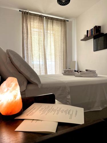 a bed in a room with a table with a paper at Gate 10 in Bari