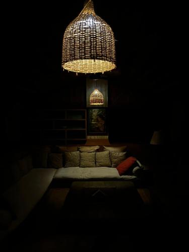 a dark room with a couch and a chandelier at Mandawa Kothi in Mandāwa