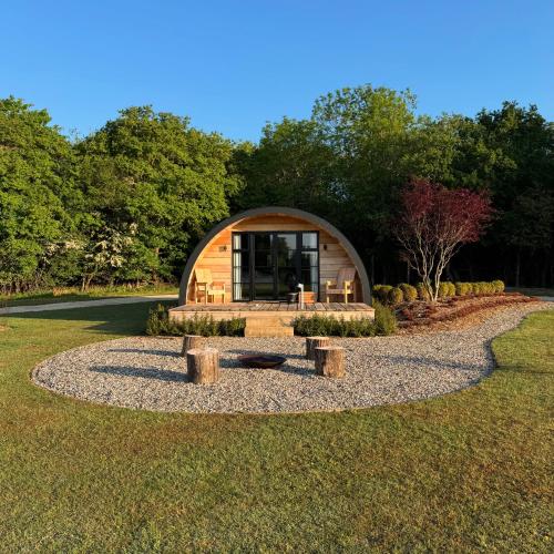a circular cabin in the middle of a park with trees at The Goose In The Woods - With Lakeside Sauna in Wellesbourne Hastings