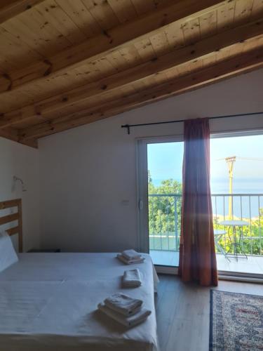 a bedroom with a bed and a large window at Manas Rooms in Dhërmi