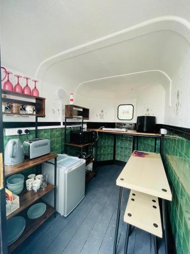 a kitchen with green tiled counters and a table at The Haycart in Tobar Pheadair