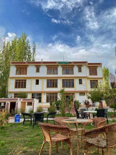 a building with tables and chairs in front of it at Hotel Galaxy Ladakh in Leh