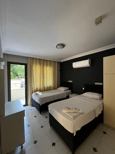 a hotel room with two beds and a window at Metropolitan apart in Marmaris