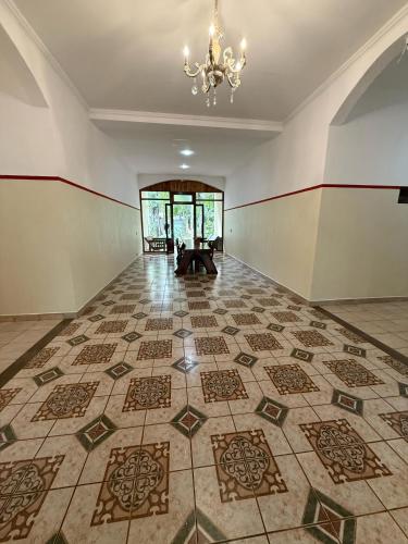 an empty room with a tile floor and a chandelier at Palo Rosa Lodge in Puerto Iguazú