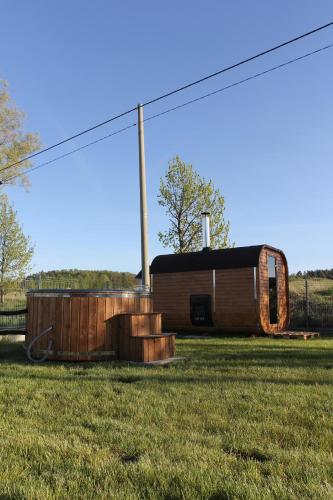 a small building in a field with a fence at Chabrowa Oaza in Sasino