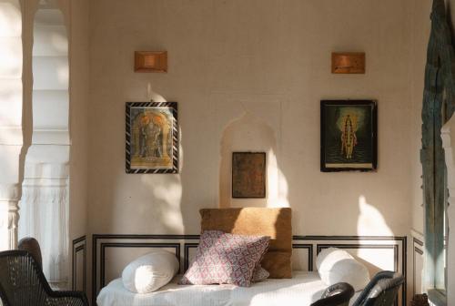 a room with a bed and some pictures on the wall at Mandawa Kothi in Mandāwa