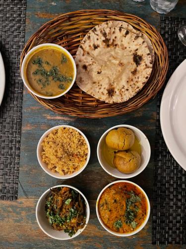 a table with bowls of food and a basket of food at Mandawa Kothi in Mandāwa