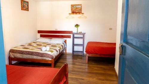 a small bedroom with two beds and a table at La Estación San Pedro in Cusco