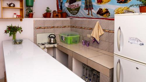 a kitchen with a counter and a white refrigerator at La Estación San Pedro in Cusco