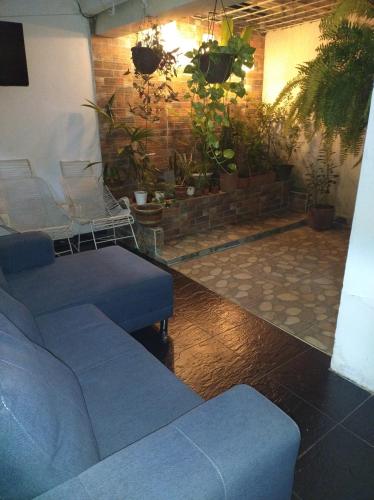 a living room with blue couches and potted plants at Casa Lina in Montería
