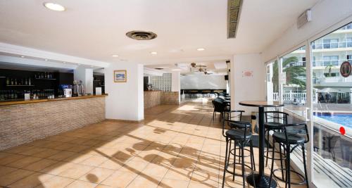 a restaurant with a bar and a pool at Sandos Griego in Torremolinos