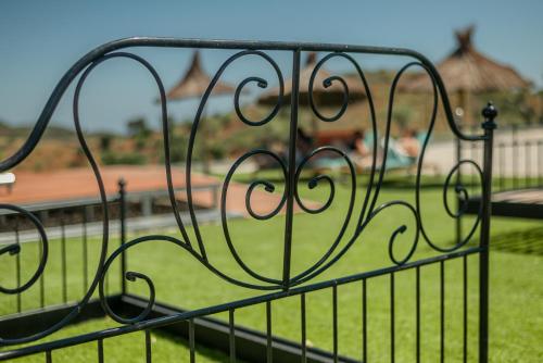 a metal fence with a view of a yard at Portugals Infinity Eco Suite Resort in Tavira