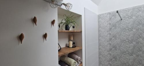 La salle de bains est pourvue de murs blancs et d'une porte de douche en verre. dans l'établissement Maison atypique centre Auxerre, à Auxerre