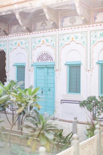 a building with a blue door and windows at Mandawa Kothi in Mandāwa