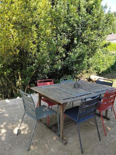 une table en bois avec quatre chaises autour dans l'établissement Maison au bord d'un cours d'eau, à Castels